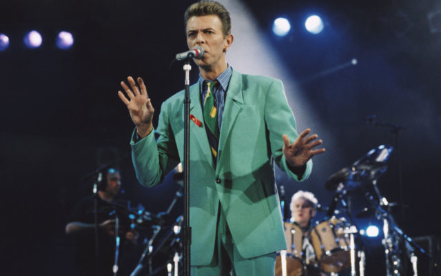 David Bowie (1947 - 2016) performs on stage at the Freddie Mercury Tribute Concert for AIDS Awareness, Wembley Stadium, London, 20th April 1992. Queen drummer Roger Taylor performs behind.